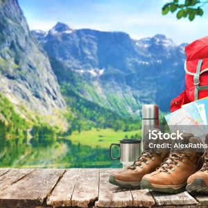 lake landscape with big backpack and trekking boots in mountains